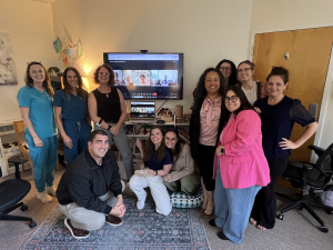 Team members from Glow Health and Wellness and New Heights Counseling gathered together during a collaborative staff meeting.